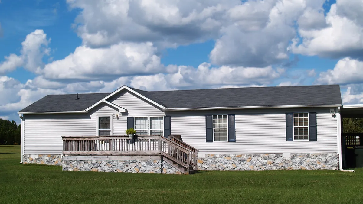Single-story manufactured home with a front deck and stone skirting